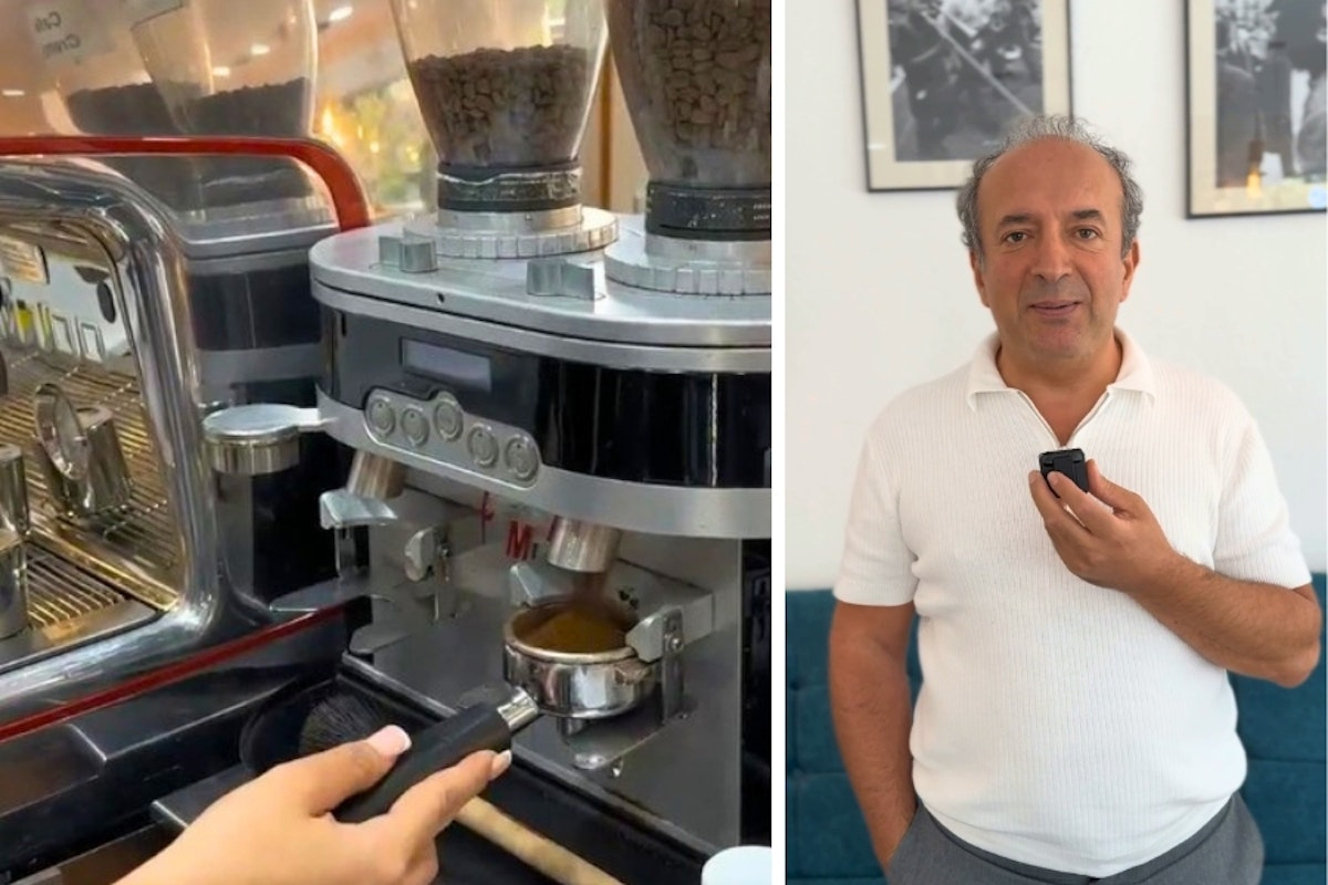 Eine Person bedient ein kleines Gerät in der Nähe einer Kaffeemaschine, während eine andere Person ein ähnliches Gerät an ihre Brust hält, im Raum steht und lächelt.