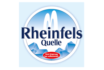 Das Logo von „Rheinfels Quelle“ mit stilisierten Bergen, zwei Wasserläufen und einem blauen Hintergrund mit Farbverlauf. In einem roten Oval unten in der Mitte steht der deutsche Text: „Vom Ursprung her vollkommen…“.